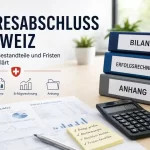 Büroszene zum Jahresabschluss Schweiz mit Ordnern für Bilanz, Erfolgsrechnung und Anhang, Finanzdokumenten, Rechner und Checkliste.